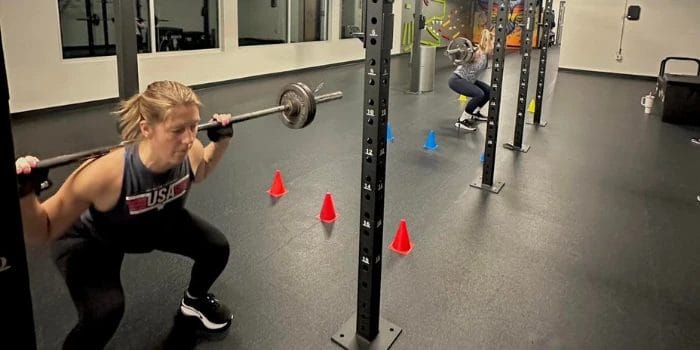 Women doing barbell squats
